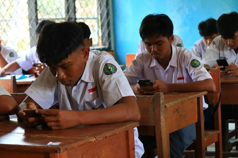 teenagers using phones for a Kahoot-style ESL quiz game