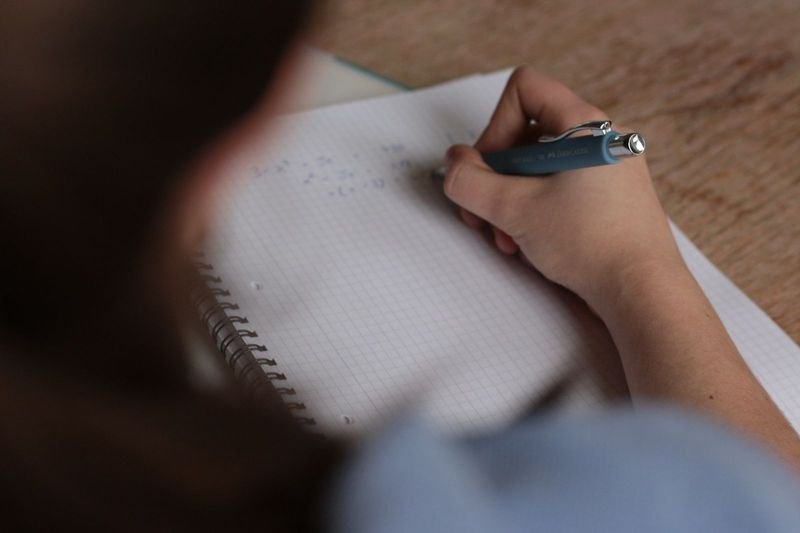 Student writing paraphrase vocabulary for IELTS speaking practice