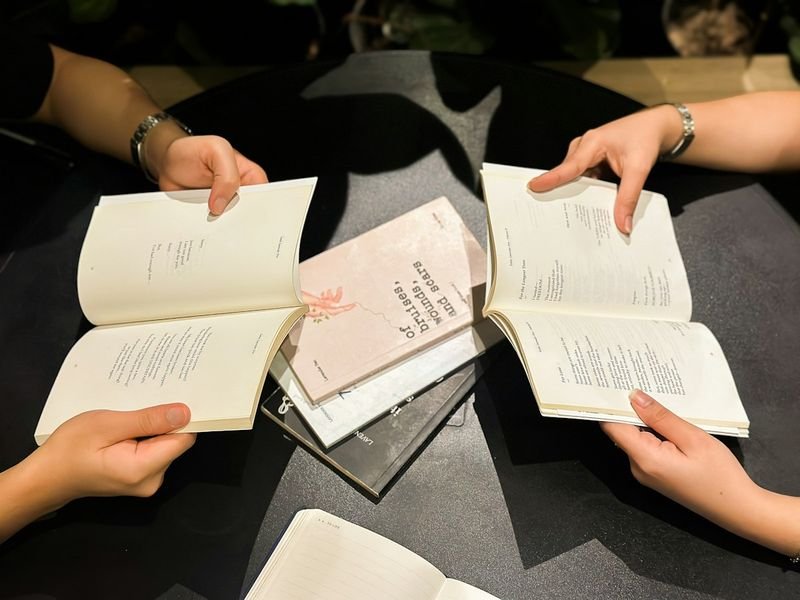 ESL students discussing an open book together during a literature circle
