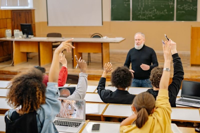 ESL students raising hands after a teacher's wait time pause