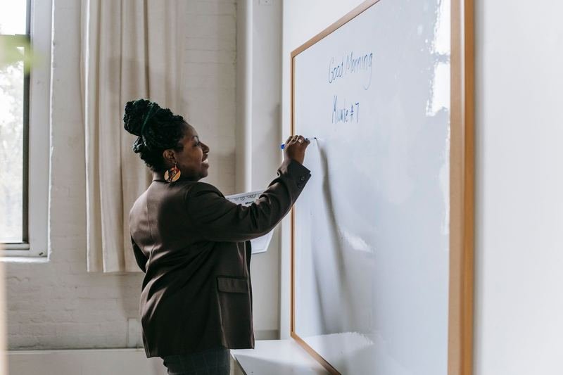 Teacher drilling word stress patterns on the classroom whiteboard