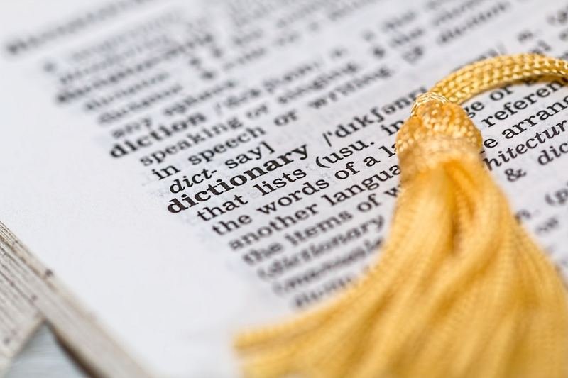 English dictionary open to a page showing word stress syllable marks