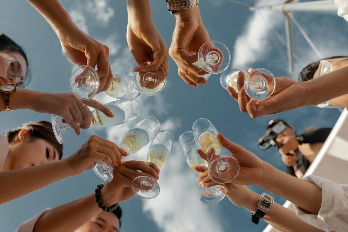 Friends toasting champagne glasses together, illustrating pull out all the stops and go out with a bang