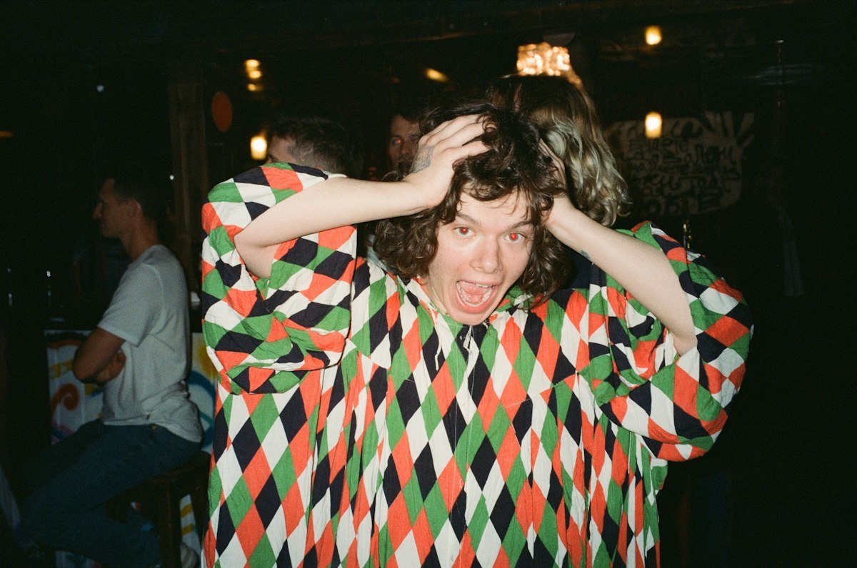 A person looking unhappy with hands on their head, illustrating the idiom party pooper