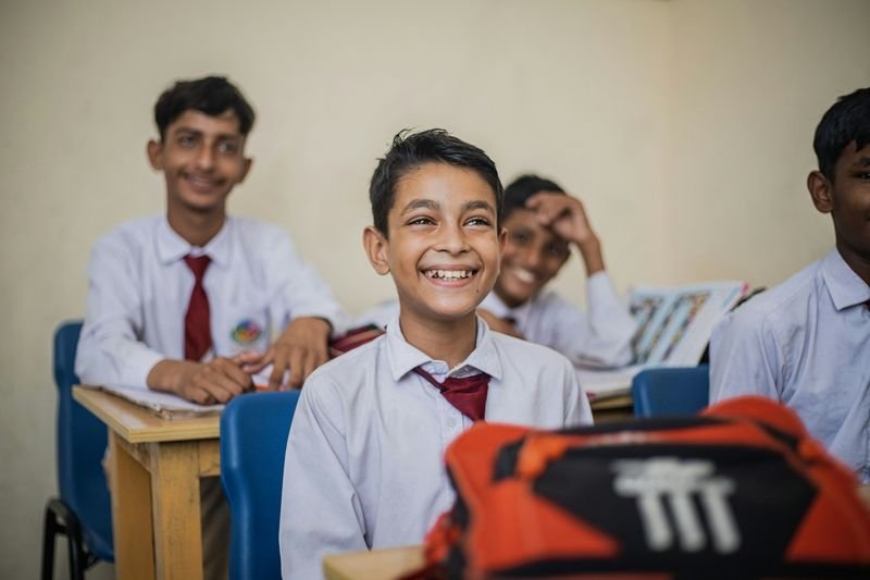secondary school ESL students in uniform smiling in classroom
