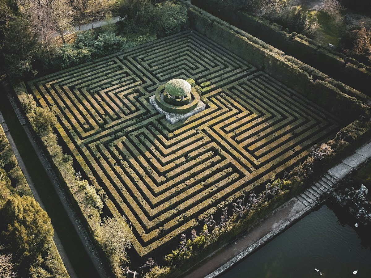 A winding hedgerow maze path, illustrating the idiom beat around the bush