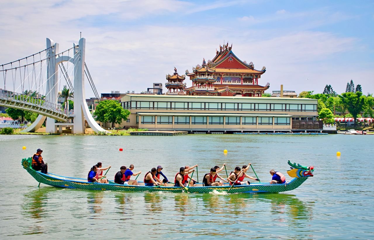 Dragon boat race near a traditional Taiwanese temple