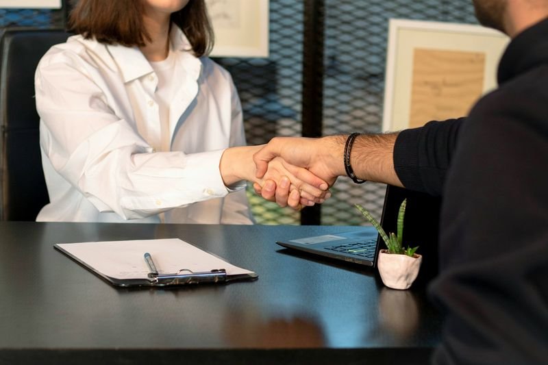 An ESL teacher shaking hands with a parent after a buxiban progress meeting