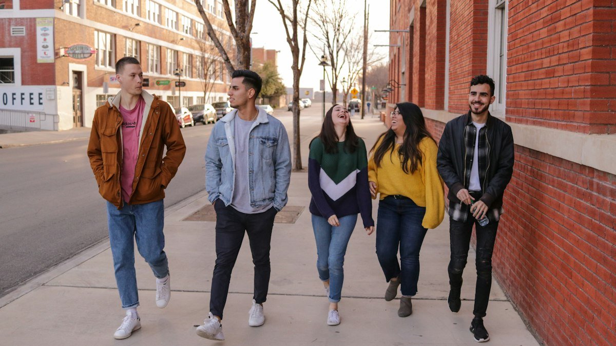 Group of friends walking side by side laughing, illustrating two peas in a pod