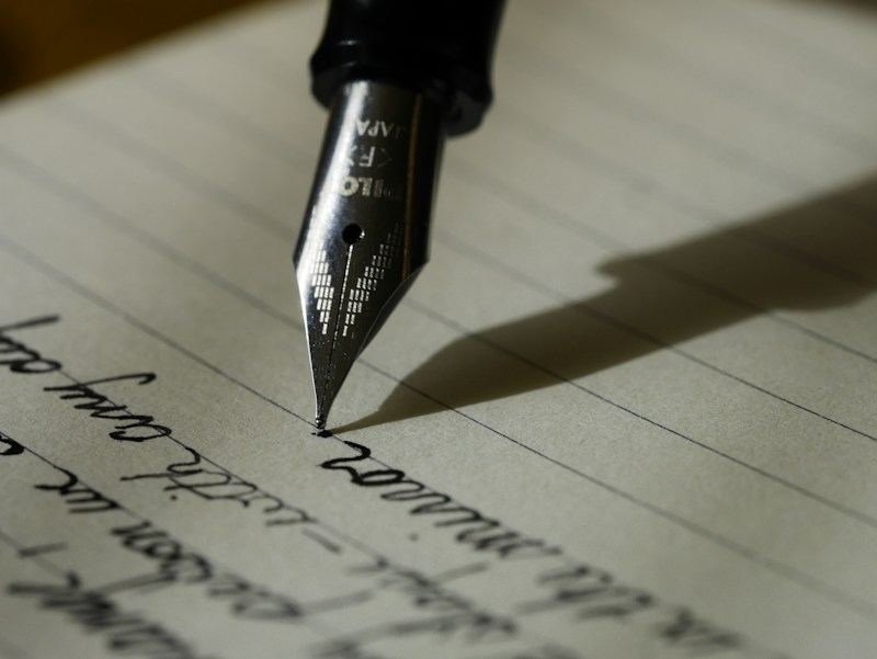 Close-up of handwriting showing end mark punctuation in a sentence