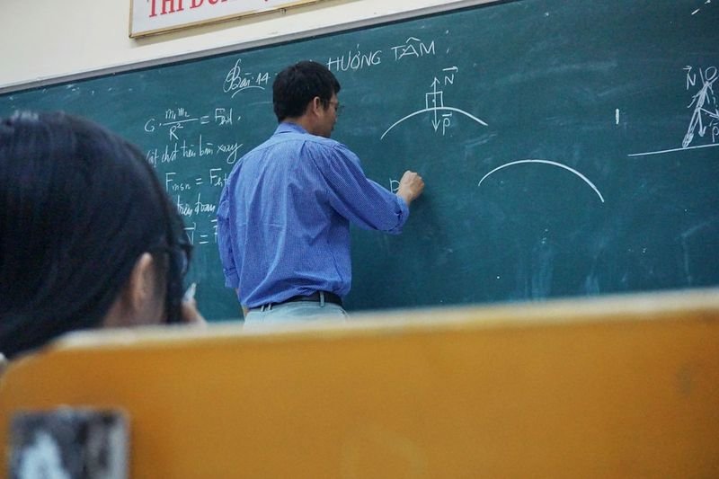 Teacher writing equations on chalkboard for logical-mathematical intelligence ESL lesson