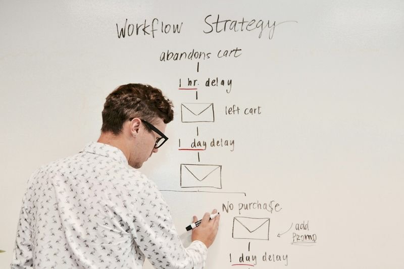 teacher writing English grammar correction on whiteboard