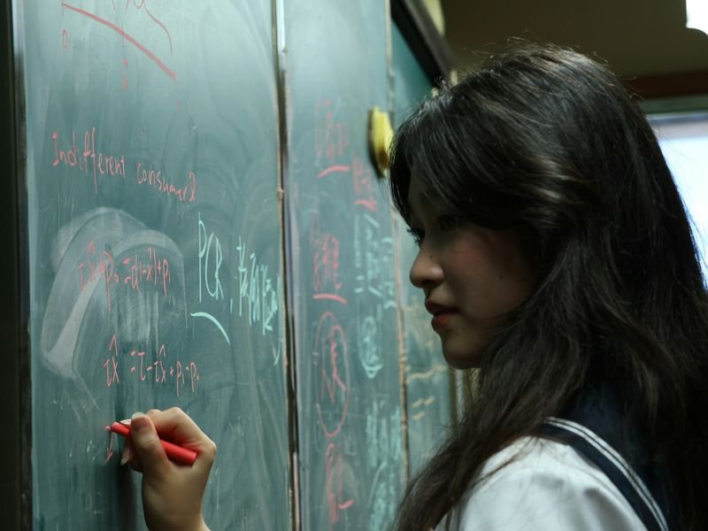 ESL student writing English sentences on the board
