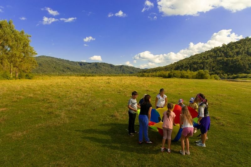 Students learning outdoors on grass field for naturalist intelligence ESL activity