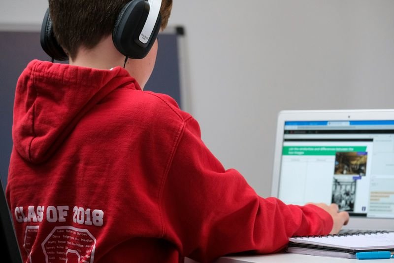 ESL student recording a voice post on Padlet with headphones