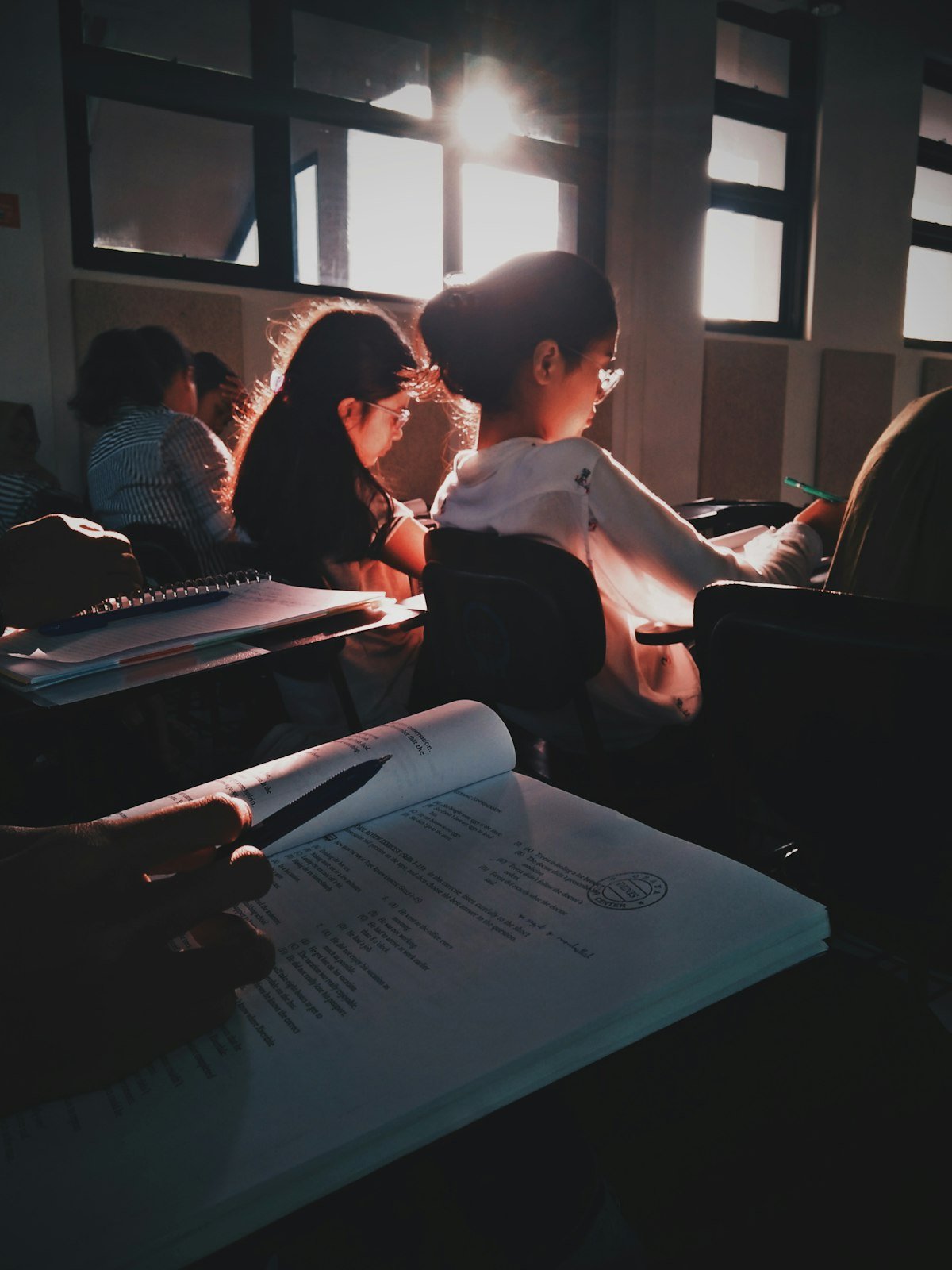 Students reading textbooks in a sunlit classroom, illustrating make the grade and ace an exam