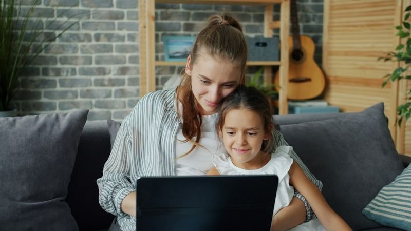 Parent and child reviewing a Seesaw family message at home