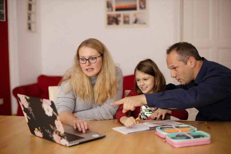 Family reading a Seesaw translated classroom update together