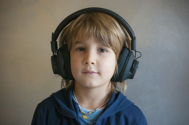 autistic ESL student using headphones in a low-sensory classroom corner