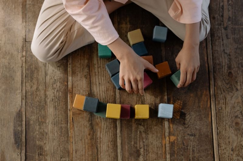 Student hands arranging colored rods similar to Cuisenaire rods used in the Silent Way method