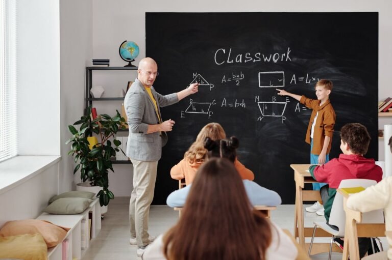 Teacher pointing at whiteboard demonstrating the Silent Way teaching method with ESL students