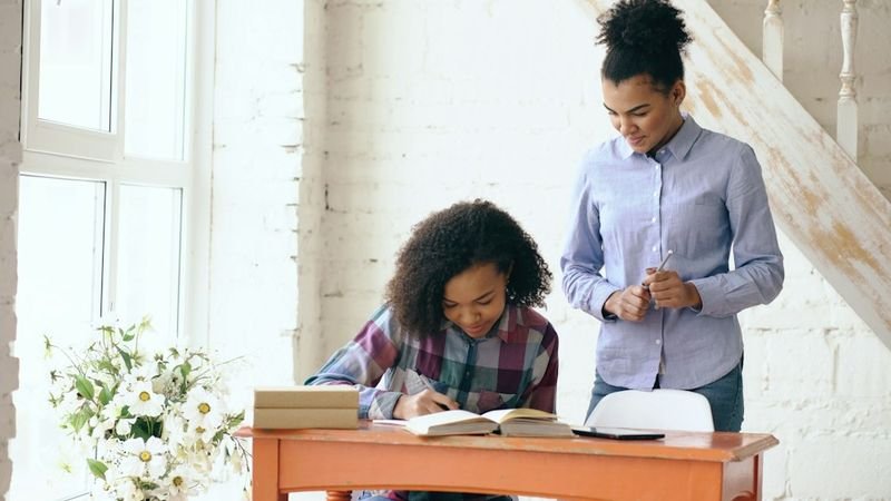 Teacher reviewing a twice-exceptional gifted ESL student's written work one on one
